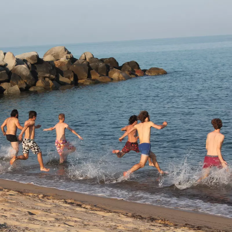 Jungen rennen ins Meer